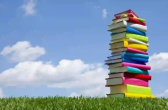 Книги на лужайке на фоне синего неба с облаками